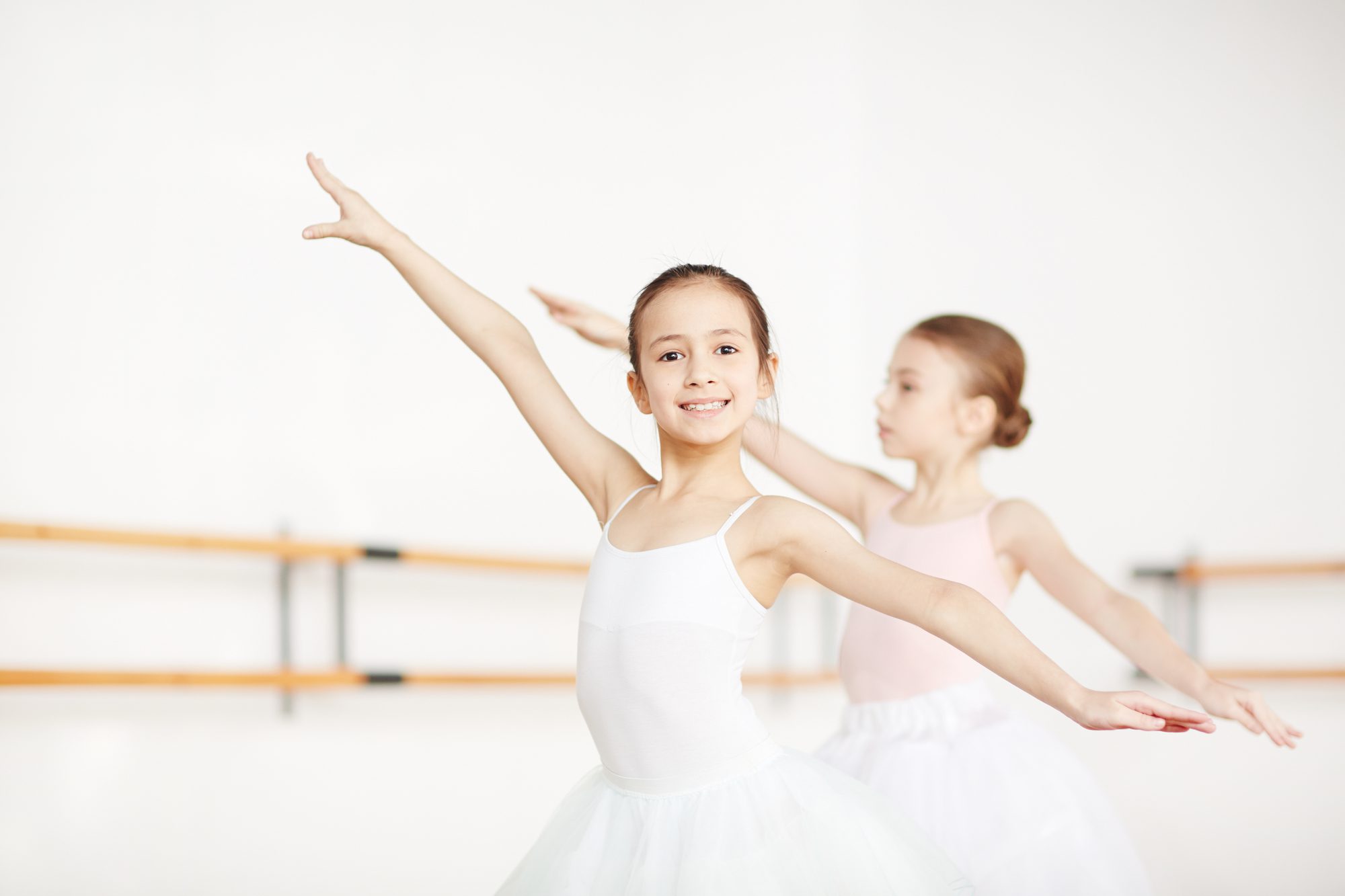 Two Little Girls Outstretching Arms While Training in Ballet Class.