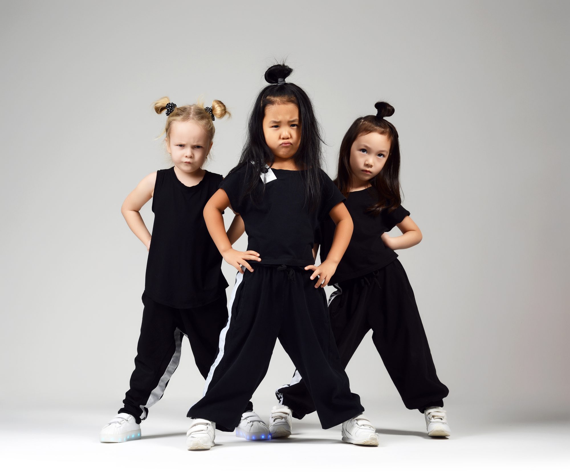 Group of Three Young Girl Kids Hip Hop Dancers on Gray Background.
